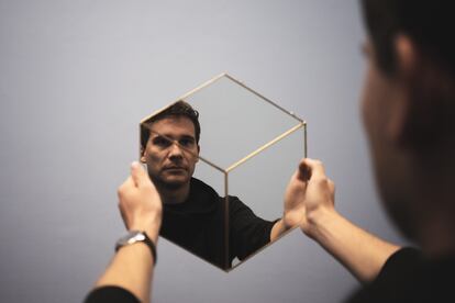 Un hombre mira su reflejo en un espejo.