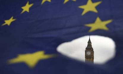 El Big Ben asoma por un roto en una bandera de la Unión Europea en Londres.