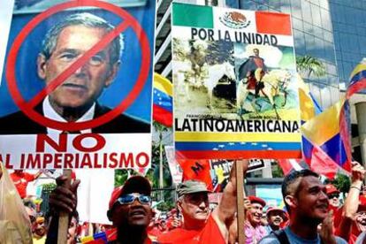 Seguidores de Chávez portan carteles contra Bush y a favor de la unidad regional en la marcha del sábado en Caracas.