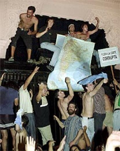 Unos manifestantes subidos en la puerta principal de la Casa Rosada.