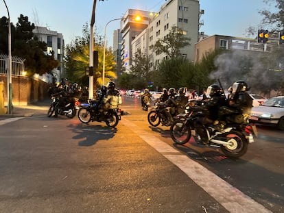 Agentes de la policía motorizados dispersan a los manifestantes en Teherán, este lunes. La policía iraní había tratado esa misma jornada de apaciguar la ira de una parte de la población por la muerte de la joven kurda, al definir su fallecimiento como “un desafortunado incidente”, pero sin cambiar su versión, que atribuye a un infarto el deceso de Amini.