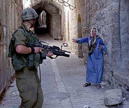 Una mujer palestina grita a un soldado israelí en el casco antiguo de Hebrón, que está bajo toque de queda.