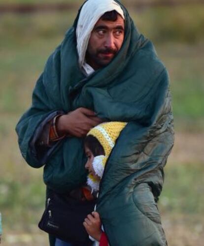 Un refugiado cubre a su hijo, junto a la localidad húngara de Roszke, cerca de la frontera de Serbia.
