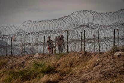 Los cruces entre Ciudad Juárez y El Paso se han multiplicado en la última semana. Se calcula que el número de interceptados cada día ha subido de 6.000 a 8.000 personas, en previsión de lo que pasará a partir de las 23.59 del jueves, cuando finalice el Título 42. En la imagen, una familia de migrantes camina junto al cerco fronterizo entre Ciudad Juárez y El Paso. 