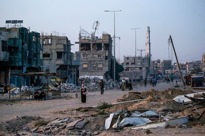 Refugiados palestinos caminan por las ruina de Jan Yunis, en Gaza.