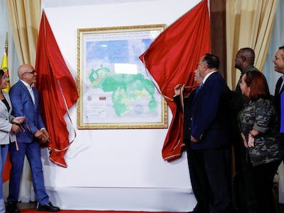 The president of Venezuela's National Assembly, Jorge Rodriguez, unveils a map of Venezuela showing the disputed Esequibo region as part of the country.