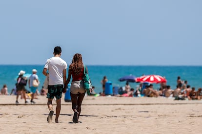 Una pareja se dirige a la orilla de la playa de la Malvarrosa de Valencia, el lunes pasado.
