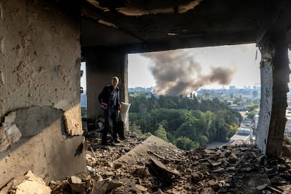 Un hombre inspecciona los restos del edificio residencial en Kiev alcanzado por el ataque ruso, este domingo. 