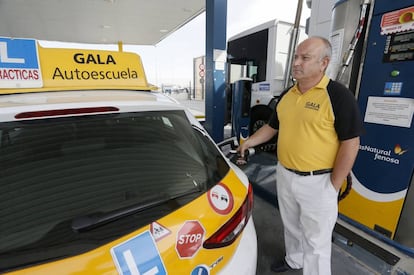Juan Luis Cardeña, profesor de la Autoescuela Gala, recarga uno de los vehículos propulsados a gas natural comprimido (GNC) de su flota.