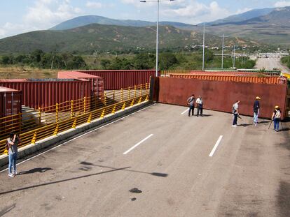 Funcionarios y periodistas inspeccionan los contenedores que bloquean el puente de Tienditas, entre Colombia y Venezuela.