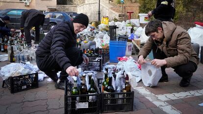 Varios ciudadanos preparan 'cócteles molotov' en una calle de Kiev este domingo.