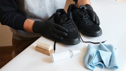 Un hombre preparando productos para limpiar las zapas.