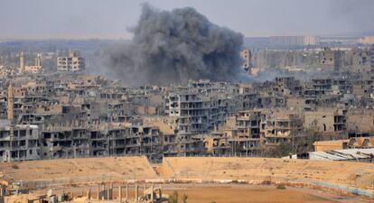 Una columna de humo se eleva sobre la ciudad de Deir Ezzor durante una operaci&oacute;n del r&eacute;gimen contra posiciones del ISIS.