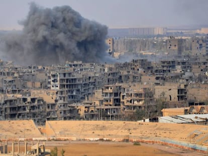 Uma coluna de fumaça se eleva sobre a cidade de Deir Ezzor durante uma operação do regime contra posições do EI.