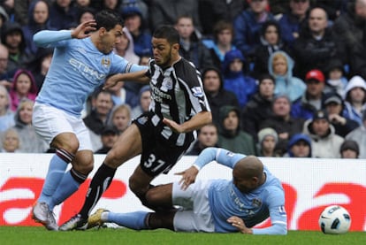 Ben Arfa, rodeado por Tévez y De Jong, recibe una dura entrada del holandés.