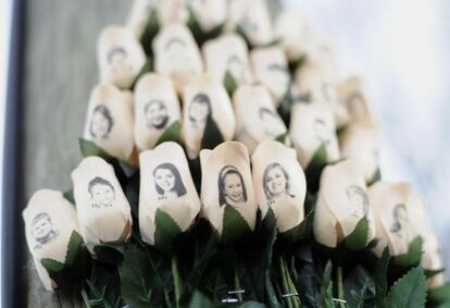Un ramo de rosas blancas con las fotografías de las víctimas de la tragedia.
