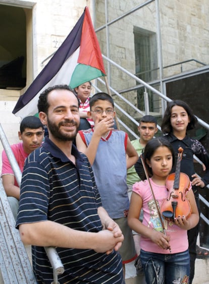 Se hacen llamar Musik Fund. Recogen instrumentos del mundo en calma para llevarlos a territorio en conflicto. Ramzi Aburedwan, director de la escuela de música Al Kamandjati, en la ciudad de Ramala, posa con sus alumnos.