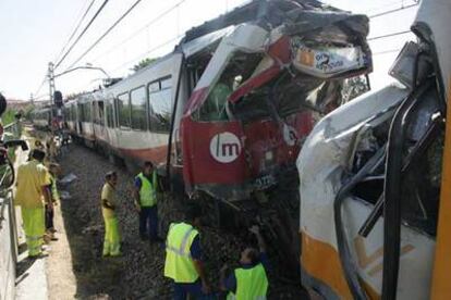 Dos operarios junto a los trenes siniestrados en Valencia.