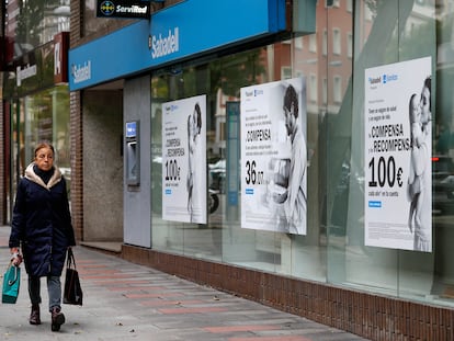 Una mujer camina junto a una oficina del Banco Sabadell en Madrid.