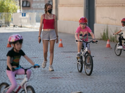 Varios niños junto a la monitora, el pasado martes durante una clase para aprender a montar en bici en Matadero Madrid.