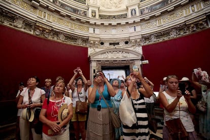 Un grupo de turistas hace fotos en la sala capitular de la catedral en Sevilla.