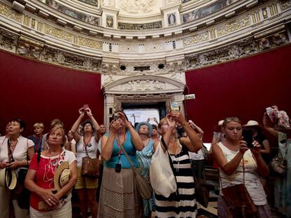 Un grupo de turistas hace fotos en la sala capitular de la catedral en Sevilla.