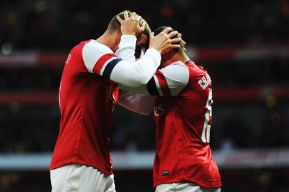 Podolski y Oxlade-Chamberlain celebran el segundo gol del partido