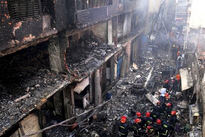 Bomberos se reúnen alrededor de los edificios que se incendiaron la noche este miércoles.