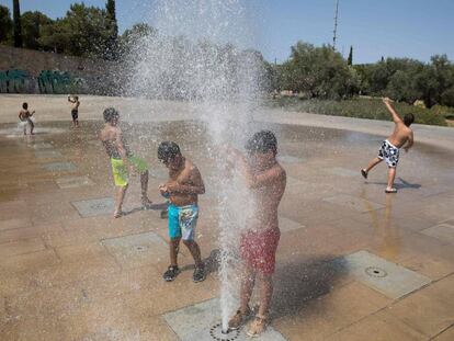 Varios niños se refrescan en unas fuentes en Palma de Mallorca.