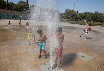 Varios niños se refrescan en unas fuentes en Palma de Mallorca.