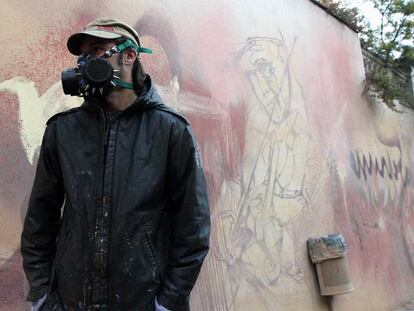 El Niño de las Pinturas, ante uno de sus <i>graffitis </i>en el barrio del Realejo de Granada.