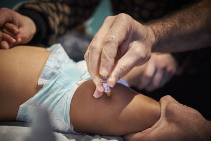 Un pediatra vacuna a un bebé en Francia.