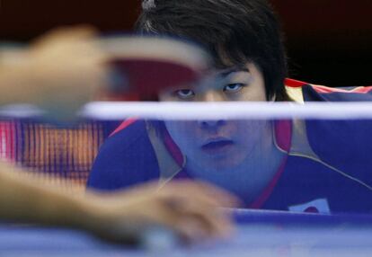 Seiya Kishikawa de Japón espera el saque de Tang Peng de Hong Kong durante el partido de cuartos de final de tenis de mesa.