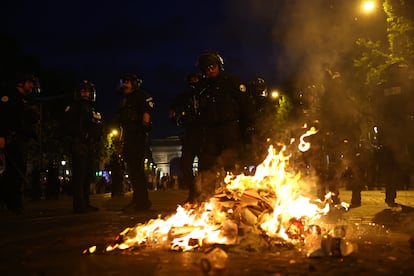 Los policías en París cerca del fuego provocado por los aficionados.