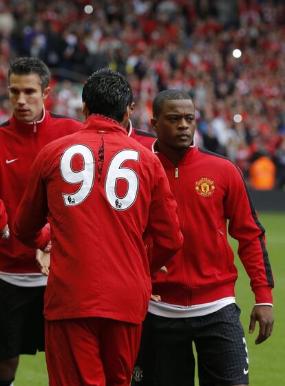 Luis Suarez y Patrice Evra estrechan sus manos.