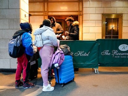 Una familia inmigrante muestra su documentación a los guardias de seguridad del Hotel Roosevelt, en enero de 2024.