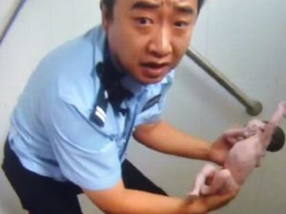 Policial segura o bebê depois do resgate.