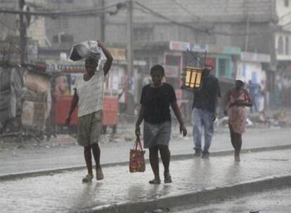 Un grupo de personas camina en Puerto Príncipe (Haití) bajo la lluvia causada por el huracán Gustav.