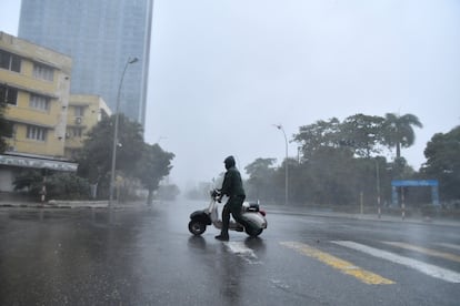 Un hombre intenta avanzar en su motocicleta mientras el huracán Rafael pasa por La Habana. 