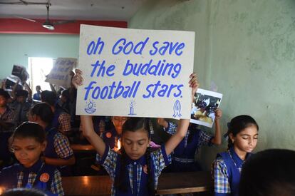 Escolares indios sostienen pancartas durante una oración por el rescate seguro los niños y el entrenador de fútbol, atrapado en una cueva en Tailandia, en Ahmedabad.