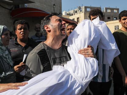 El cuerpo de un palestino muerto en un ataque aéreo israelí era sacado de la morgue del Hospital Al Aqsa para ser enterrado en Rafah, Gaza, el domingo.