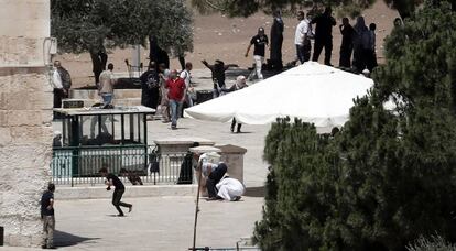 Un grupo de palestinos se enfrenta a la polici&iacute;a israel&iacute; este lunes junto a la mezquita de Al-Aqsa, Jerusal&eacute;n.