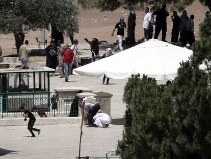 Un grupo de palestinos se enfrenta a la polici&iacute;a israel&iacute; este lunes junto a la mezquita de Al-Aqsa, Jerusal&eacute;n.