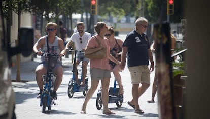 Turistas circulan por la acera en la Barceloneta.