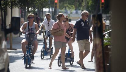 Turistas circulan por la acera en la Barceloneta.