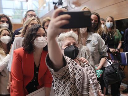 La diputada Isabel Redondo hace una fotografía de varios diputados del PP con la presidenta en funciones de la Comunidad de Madrid, Isabel Díaz Ayuso, tras el acto de constitución de la Asamblea de Madrid.