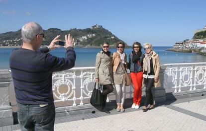 Un grupo de turistas se hace fotos en el donostiarra Paseo de la Concha.