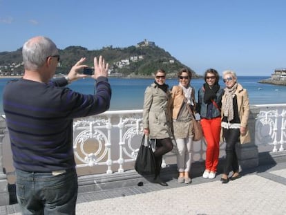 Un grupo de turistas se hace fotos en el donostiarra Paseo de la Concha.