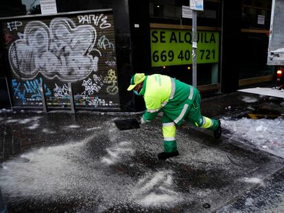 Un operario esparce sal en una acera de la calle Bravo Murillo