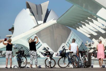 Cuatro turistas visitan la Ciudad de las Artes y de las Ciencias de Valencia.